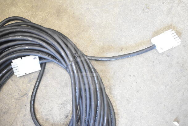 Coiled black cable with white connectors, labeled "TF CABLE FLEXTREME 5VC," on concrete floor, new condition.