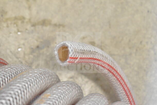 Flexible braided hose with red stripe, showing inner insulation. Used for fluid transport, in good condition.