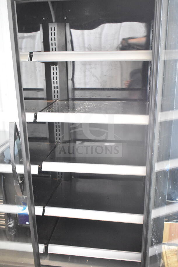 2021 True TVM-48SL-HC commercial 2-door cooler, black interior, with visible tag on handle, 115V, 1 phase.