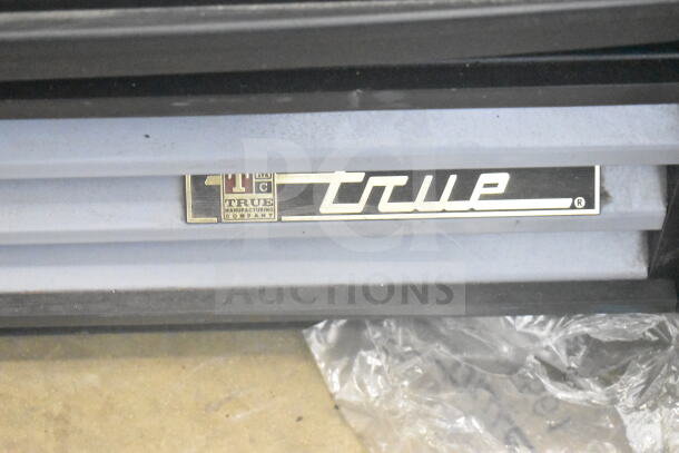 True GDM-12 Commercial Cooler badge, True Manufacturing Co. logo, visible on the unit.