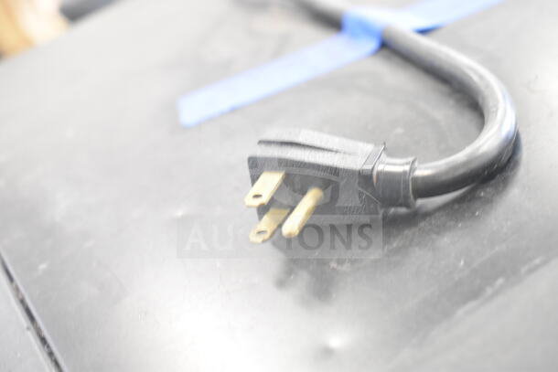 Close-up of a power cord plug for a True GDM-12 cooler, showing three-prong configuration.