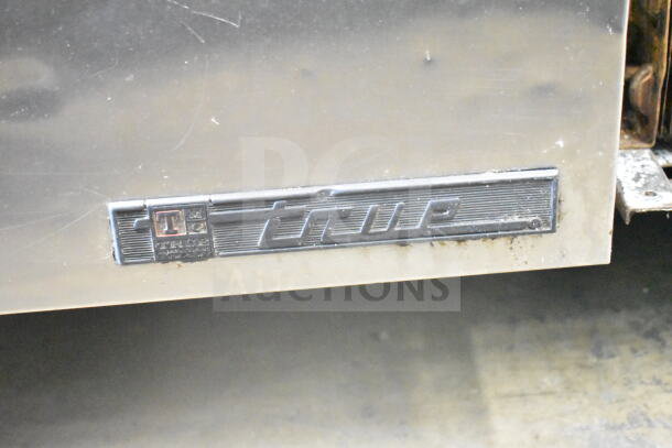 True TPP-67D-4 pizza prep table close-up showing brand logo, stainless steel finish, and slight wear indication.