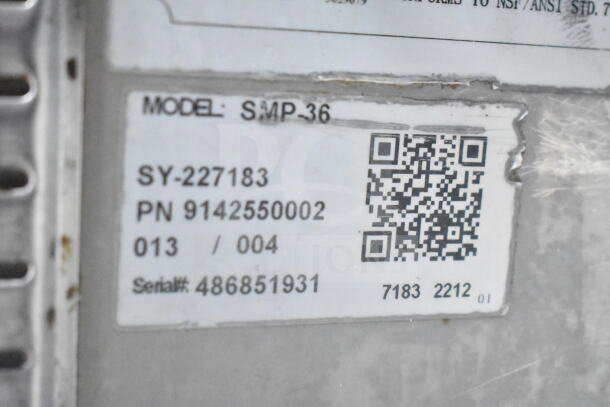 Coldline SMP-36 label showing model, serial number 486851931, and QR code on commercial prep table with missing lid part.