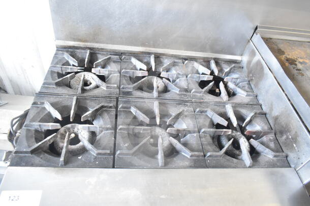 American Range commercial gas-powered 6-burner range with flat top griddle, 2 ovens, backsplash, and overshelf. Used condition.
