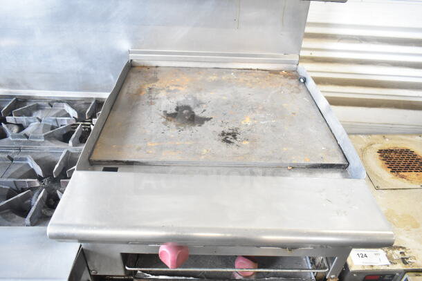 American Range commercial gas-powered 6 burner range with flat top griddle, 2 ovens, backsplash, and overshelf. Used condition.
