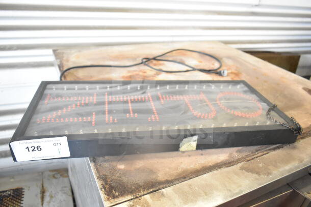 Open light-up sign with red LED lights, black frame. Visible power cord and mounting chain. Auction tag with number 126.
