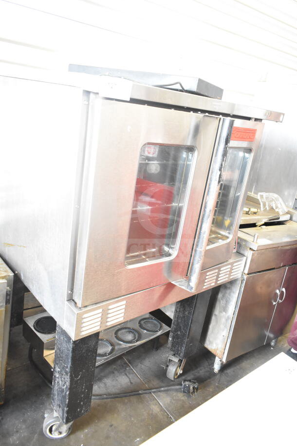 Garland commercial gas convection oven with view-through doors, thermostatic controls, metal legs, and casters.