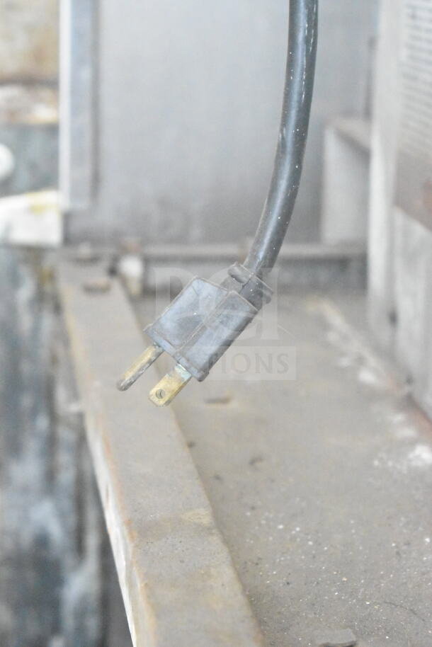 A worn electrical cord plug from the Garland convection oven, indicative of usage and potential maintenance needs.