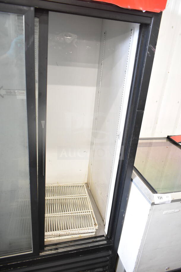 True GDM-37 commercial 2-door cooler merchandiser, 115V, 1 Phase. Features sliding glass doors and shelving. Signs of wear.