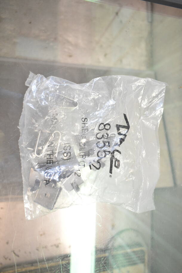 Clear plastic bag containing Dyke shelf clip kit, model 835592, for use in chest freezer merchandiser.