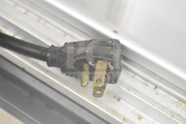 Power cord plug of a Chest Freezer Merchandiser, 115V, 1 Phase, showing signs of wear. Close-up view.