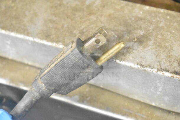 A close-up of a dusty electrical plug against a metal surface, related to the Blodgett convection oven.