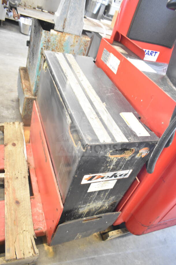 Raymond Deka 19-F60L Forklift with battery, missing forks. Visible wear on casing. Labels indicate model and brand.