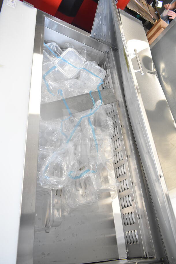 Brand new Avantco 178ZPT60MHC commercial sandwich salad prep table, 115V, with plastic containers inside.