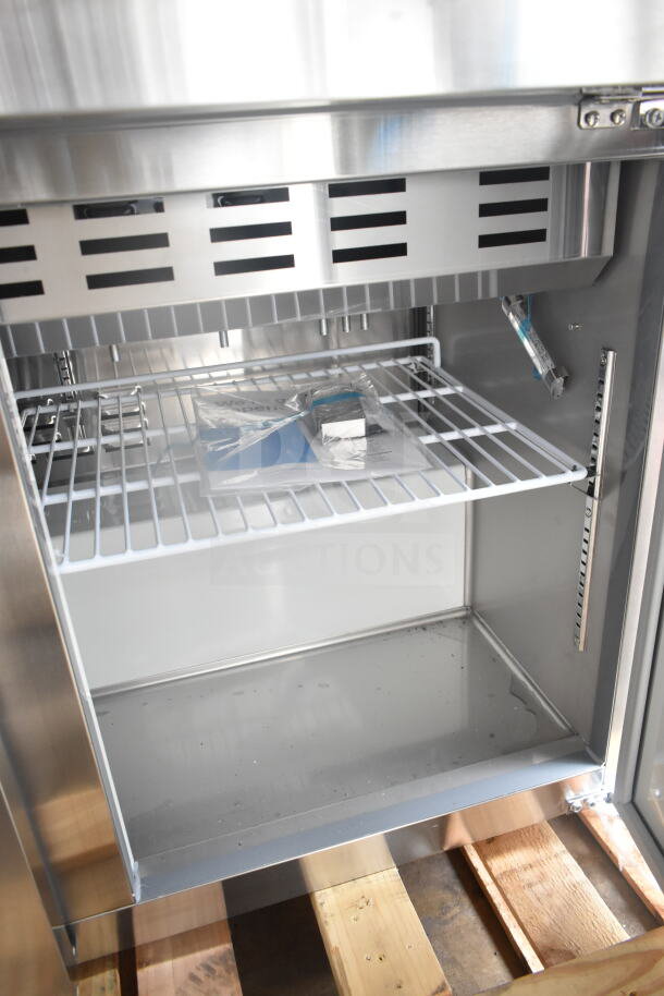 Brand new 2025 Avantco 178APT71MHC commercial sandwich salad prep table interior; scratch and dent; visible shelving and wiring.
