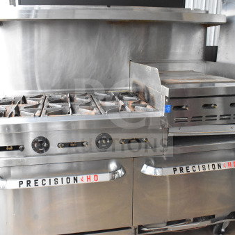 PrecisionHD gas-powered range with 6 burners, flat top griddle, 2 ovens, shelf, backsplash, casters, commercial use.