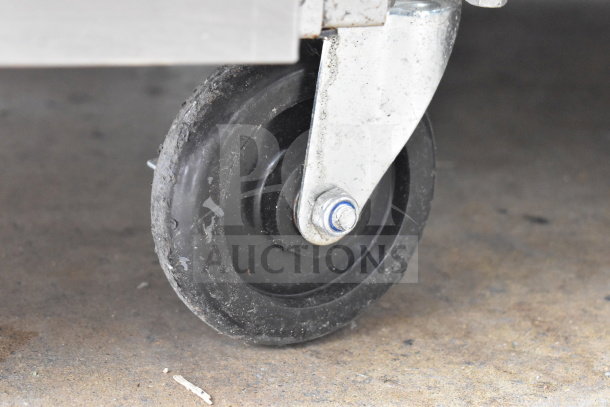 Close-up of a commercial caster wheel on a PrecisionHD gas-powered range, showing durable metal and rubber materials.