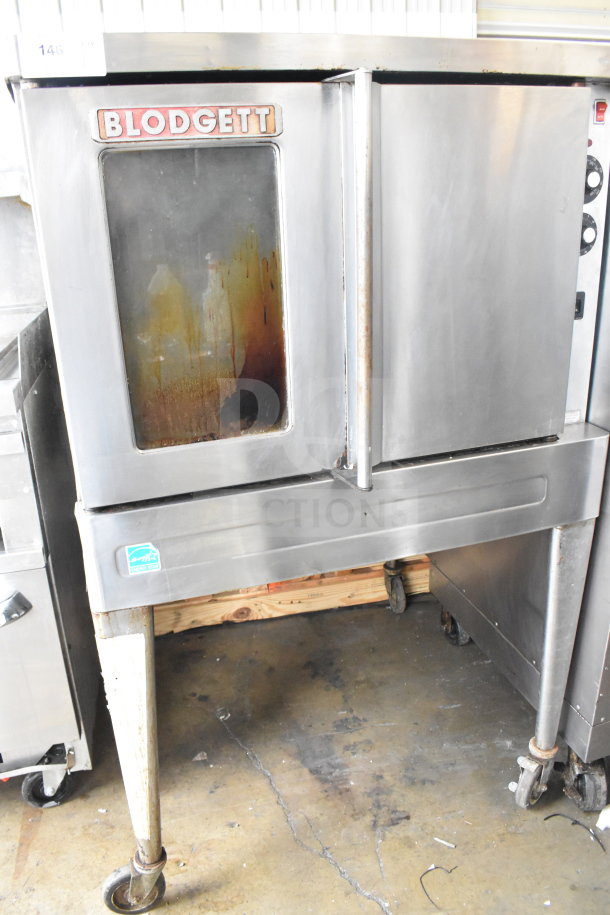 Blodgett full-size convection oven with view-through and solid doors, thermostatic controls, on metal legs and casters. Signs of wear.