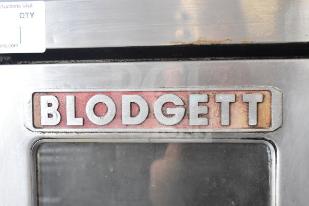 Blodgett commercial convection oven with viewing door, solid door, thermostatic controls, metal legs, and casters. Signs of use.