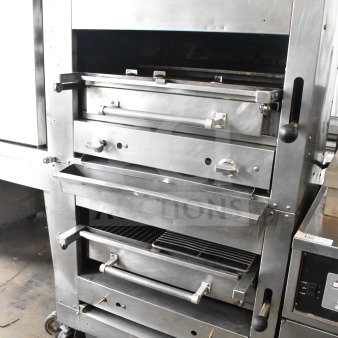 Commercial gas-powered upright 2-deck broiler on casters, industrial-grade stainless steel, dual handles, visible control knobs.