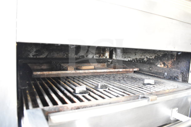 Commercial gas-powered upright broiler, two-deck, on casters. Shows grill interior with signs of use and metal surface.