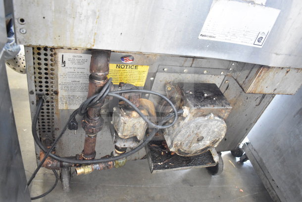 Southbend commercial gas flat top griddle with convection oven, shows signs of use, on commercial casters, visible caution and notice labels.