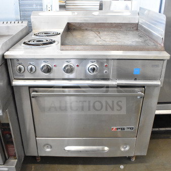 Garland commercial flat top griddle with 2 burners and oven, stainless steel, control knobs, some surface wear, sturdy build.