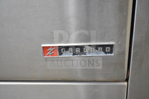 "Garland Commercial Flat Top Griddle, visible logo, durable stainless steel finish, includes 2 burners and oven."