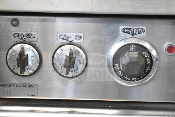 Garland commercial griddle control panel close-up, showing temperature knobs for front, rear burners, and oven. Visible wear.