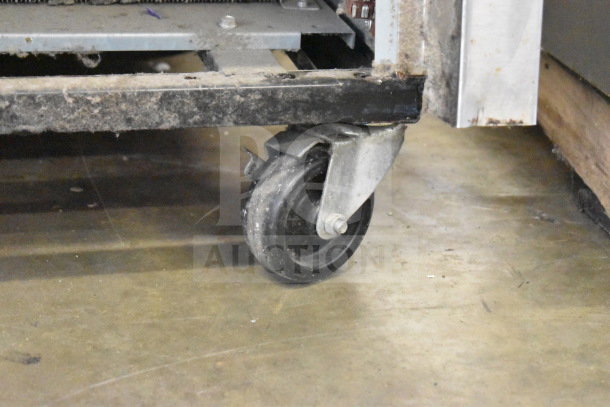 2018 True T-35-HC commercial 2-door reach-in cooler on casters, shown with detail of caster wheel; some wear visible.