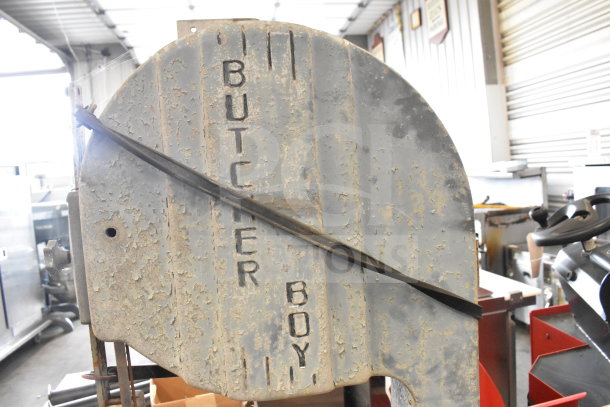 Butcher Boy commercial meat saw, floor model, used condition, showing wear and surface rust, prominent brand name.