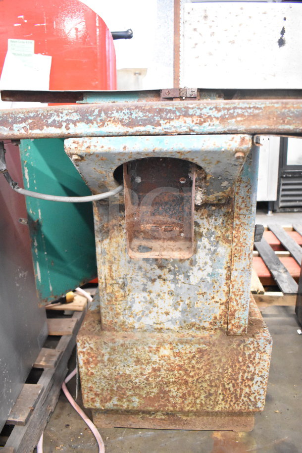 Butcher Boy commercial floor-style meat saw, showing signs of rust and wear, sturdy metal base, used condition.