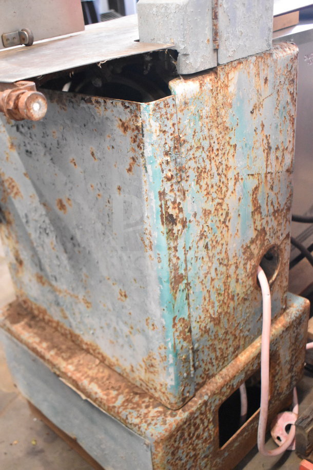 Butcher Boy commercial meat saw with a rusted exterior, indicating wear. Floor-style design, visible wiring.