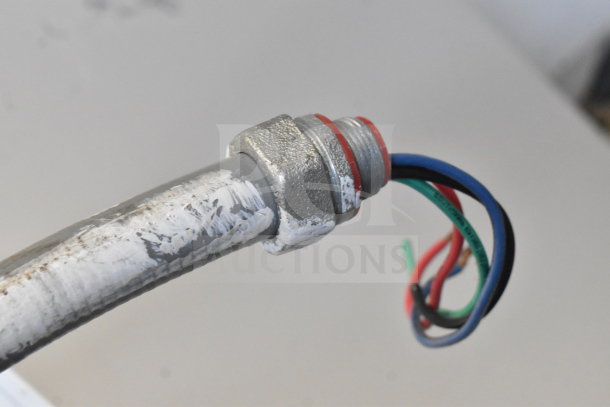Close-up view of connection wires and metal conduit from Hobart AM15 dishwasher. Visible wear on conduit, suitable for repair.