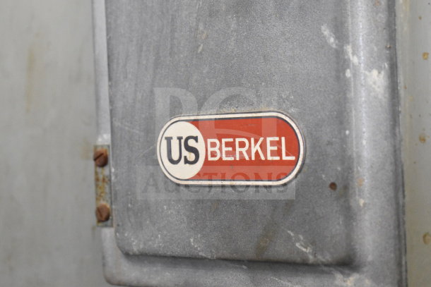 US Berkel commercial floor-style meat saw, 208 volts, 3 phase, metal exterior with visible logo. Some signs of wear.