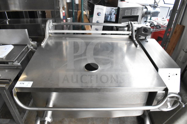 Commercial stainless steel floor-style manual tilt braising pan in excellent condition, with control handle and spout.