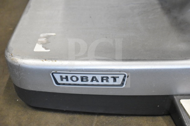 Hobart commercial countertop meat slicer, visible brand label, 120 volts, used condition with minor surface wear.