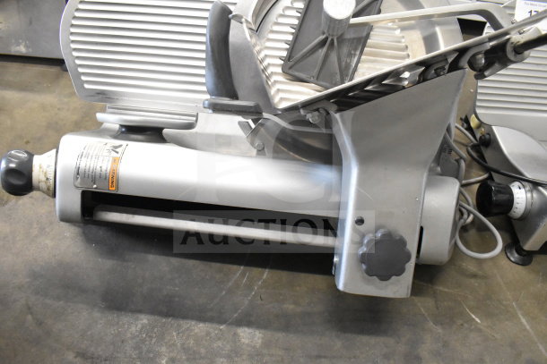 Hobart Commercial Countertop Meat Slicer, 120 Volts, 1 Phase. Features stainless steel construction, adjustable slicing knob, and operational warning label.