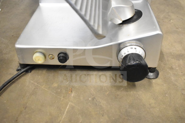 Manconi 300 IX meat slicer, silver finish, with blade sharpener, control knobs, and 120V plug; used condition.