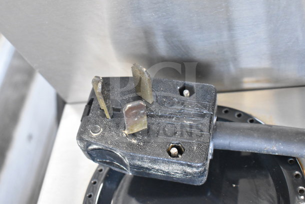Close-up of the plug from a 2018 Bunn AXIOM 0/6 TWIN commercial coffee machine, showing prongs and surface wear.