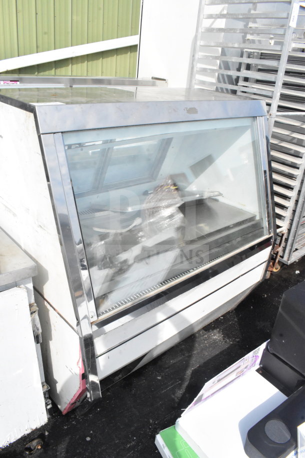 Commercial floor-style deli display case, durable stainless steel, glass front, spacious interior, minor wear visible.