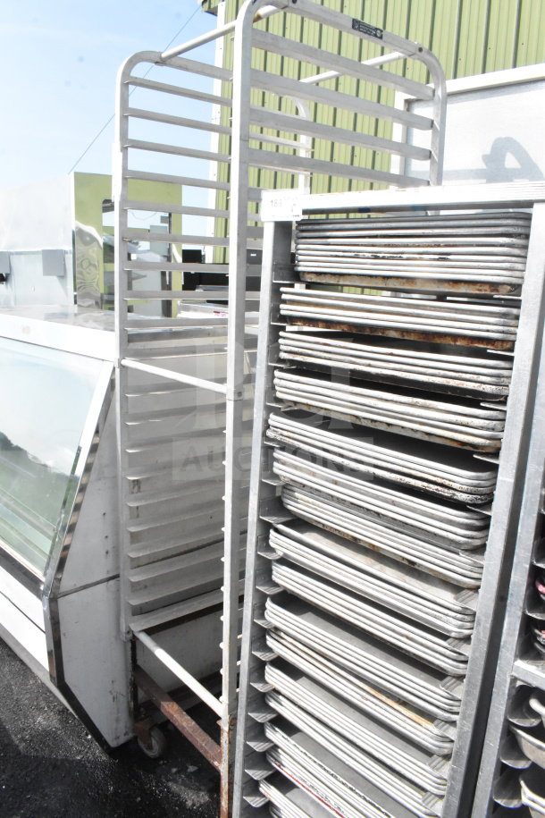 Commercial pan transport rack with multiple shelves and sturdy casters, suitable for bakery use.