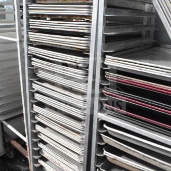 Commercial pan transport rack with 70 baking pans on casters, used condition, suitable for bakery or kitchen use.