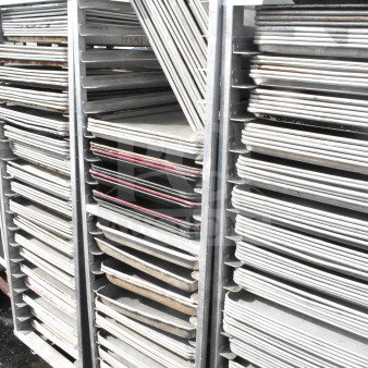 Commercial pan transport rack with 50 baking pans on casters. Sturdy metal construction, ideal for catering and baking needs.
