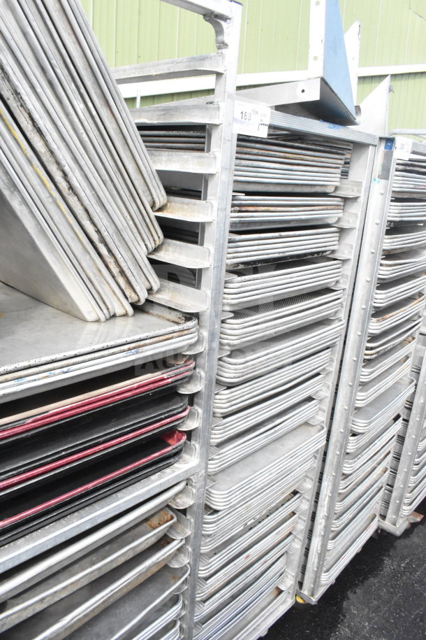 Commercial pan transport rack with 70 baking pans on casters. Sturdy metal frame, visible wear on pans.