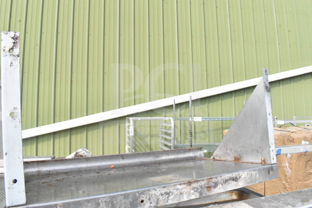 Commercial pan transport rack with casters, includes 70 baking pans. Visible wear and rust. Ideal for bakeries.