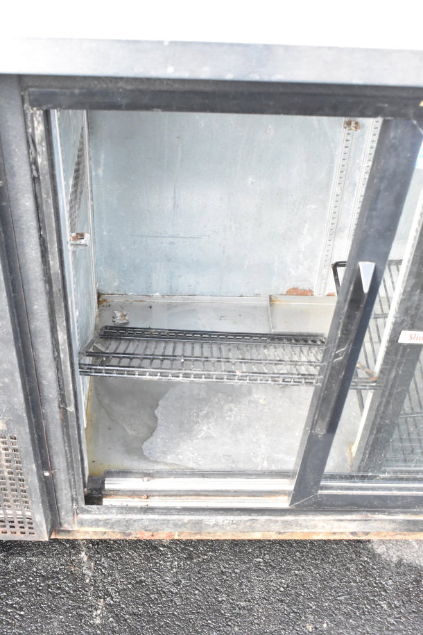 True TBB-24-48G-SD commercial 2-door bar cooler, glass doors, shelving inside, visible wear, 115 volts, 1 phase.