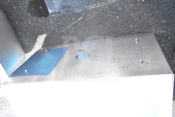 Commercial stainless steel ice bin drop-in with blue mounting plate, visible wear and connection fitting.