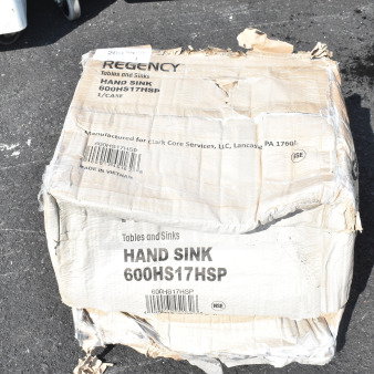 Box of Regency 600HS17HSP wall-mounted hand sink, new with scratches and dents. Contains size and branding labels.