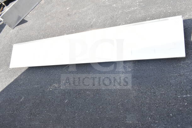 Three various white metal shelves, in good condition, laid on pavement. Auction deal: 3 times your bid.